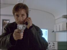 Fox Mulder aims a gun in 1997